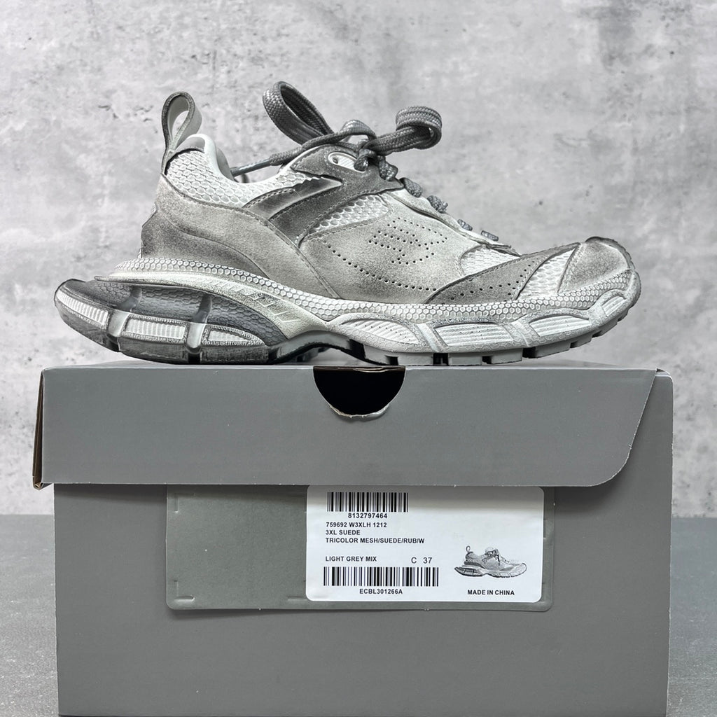 Light gray lace-up Balenciaga sneakers on a box, chunky rubber sole