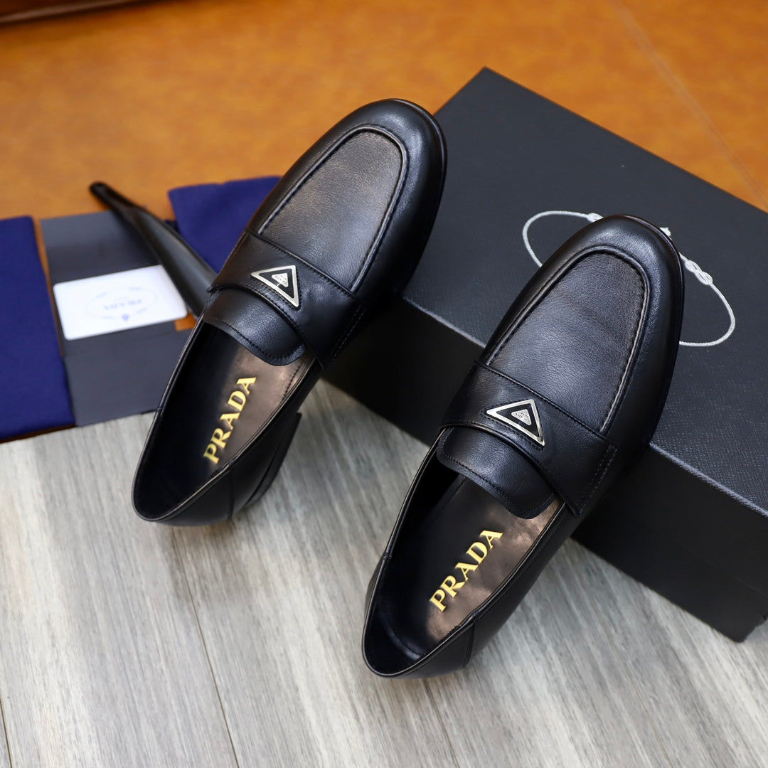 Black leather loafers with Prada triangle emblem, showing logo on lining