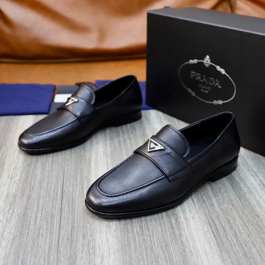 Black leather loafers with buckle strap detail and Prada logo on front