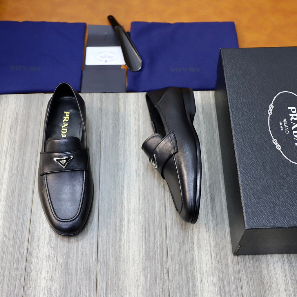 Black leather loafers with Prada triangle emblem and side strap detail