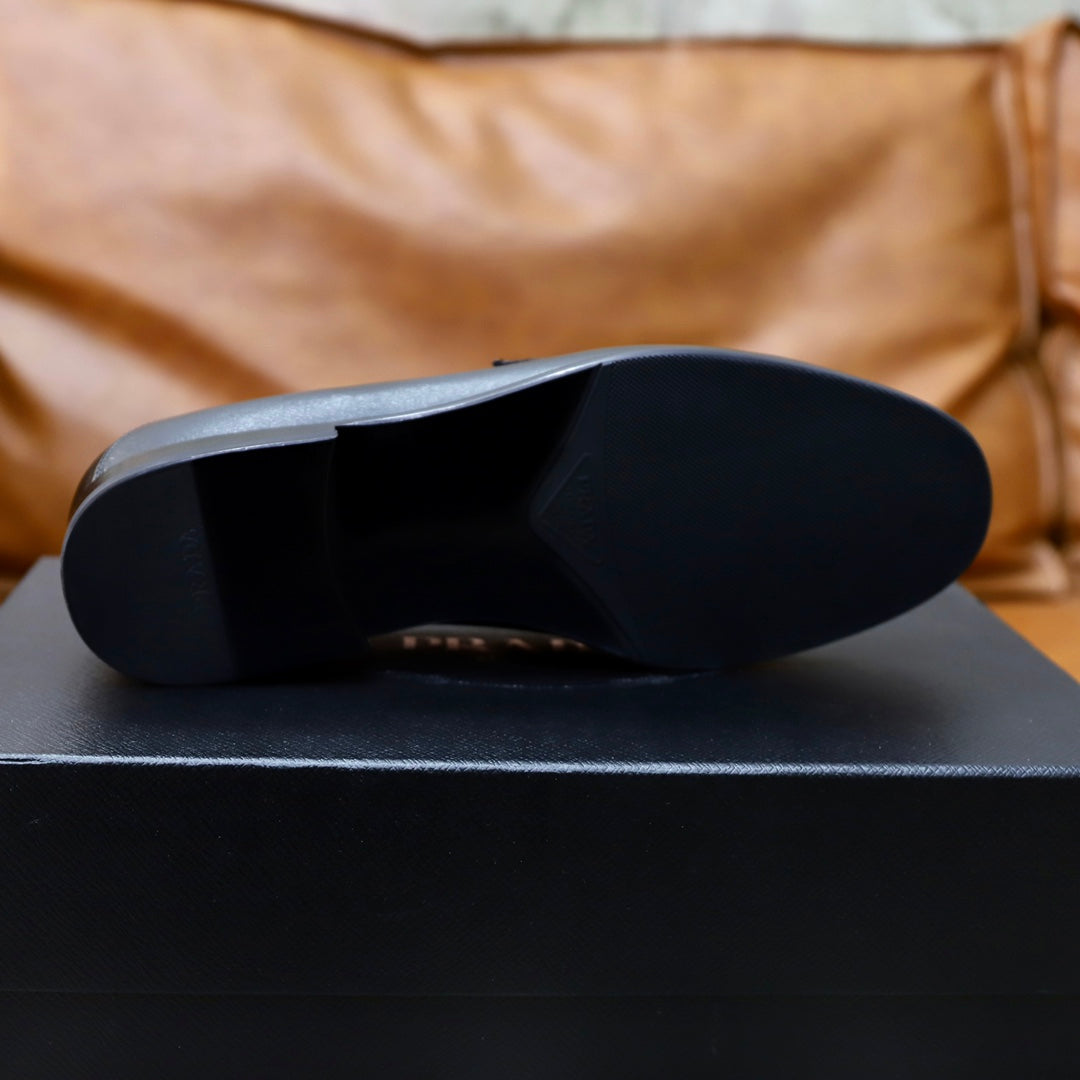 Black leather loafer outsole view on a product box