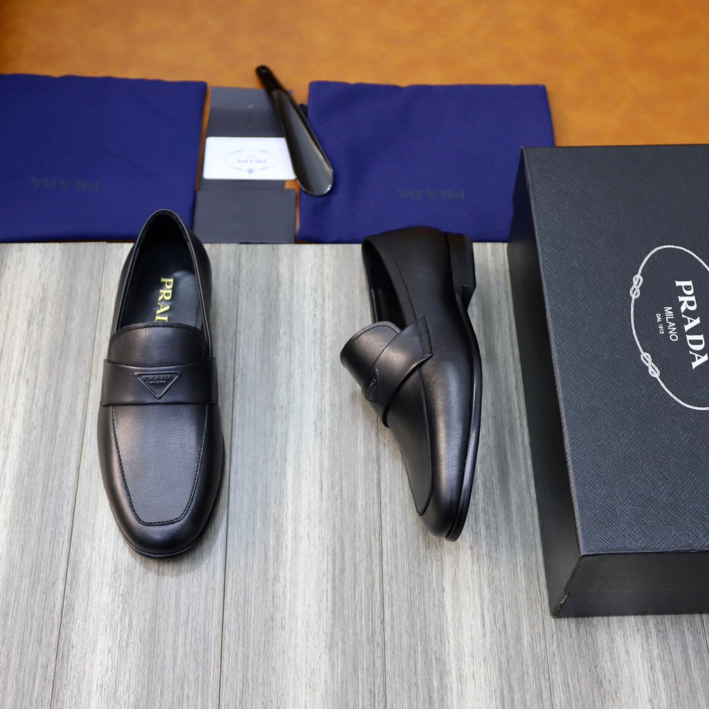 Prada unisex black leather loafer, side view with strap detail and logo badge