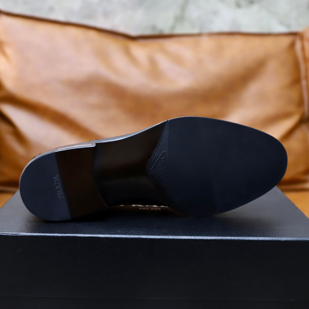 Black leather shoe outsole view with cushioned heel and smooth tread