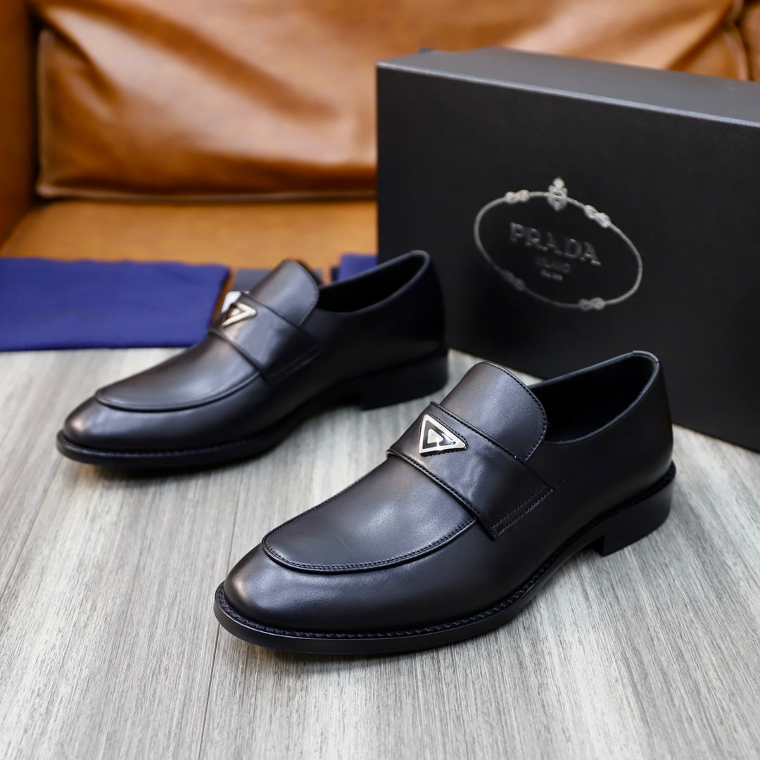 Prada unisex black leather loafers, front view on box with metal-triangle logo strap