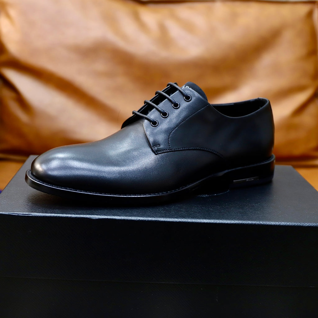 Black leather lace-up oxford shoe on black box, front view
