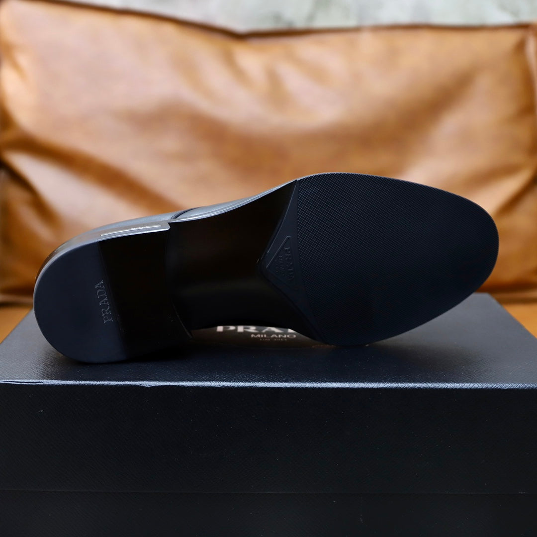 Black leather oxford shoe soles shown on black box