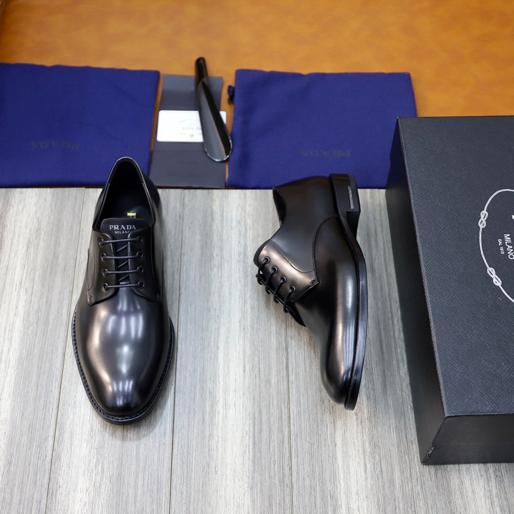Prada unisex lace-up oxfords in dark shiny leather with side profile and black laces.