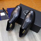 Prada black leather lace-up oxford shoes, close front view with branding on tongue