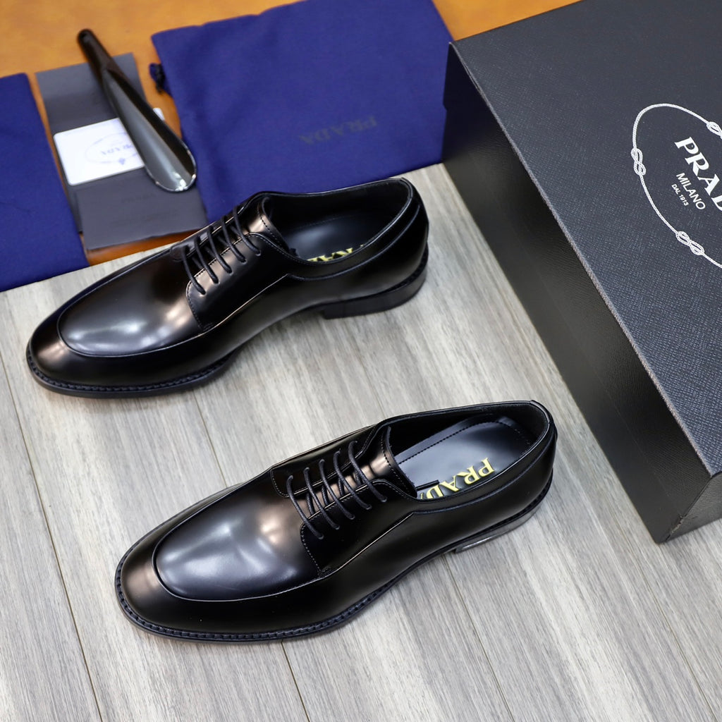Black leather oxford shoes, angled front view with lace-up and low sole.