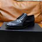 Black leather oxford shoe on box, lace-up front and rubber sole.