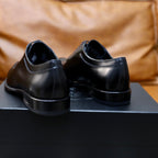 Black leather oxford shoes rear view with low heel and smooth back collar.