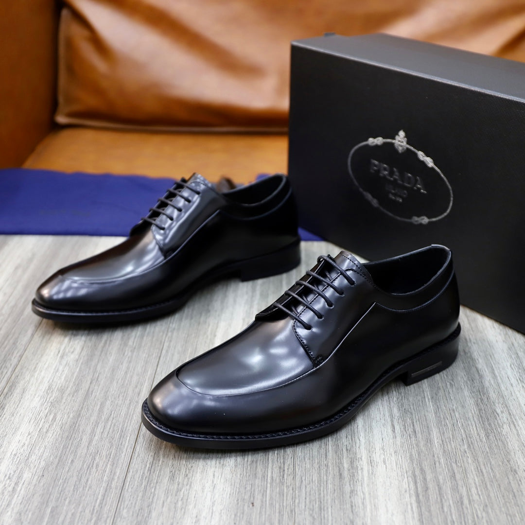 Black leather oxford shoes with lace-up vamp and stitched detailing on box.