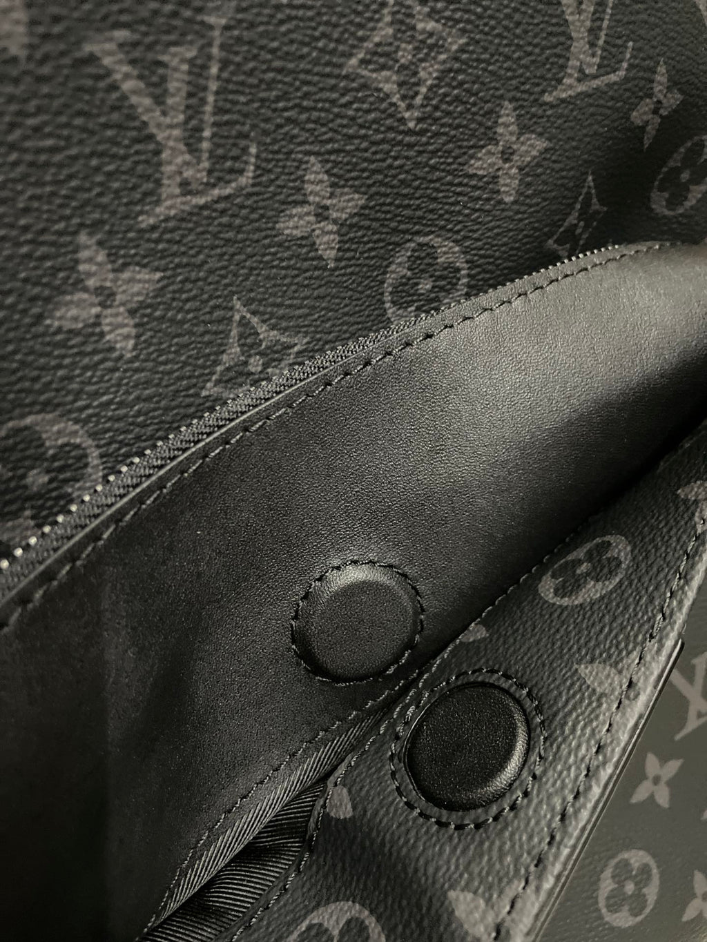 Dark monogram mini backpack front pocket with snap buttons and stitched edge