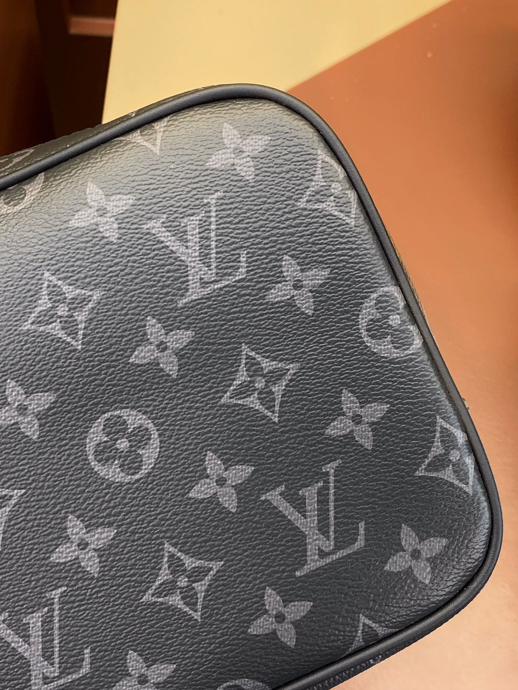 Louis Vuitton monogram toiletry pouch corner detail, dark gray leather trim and stitching