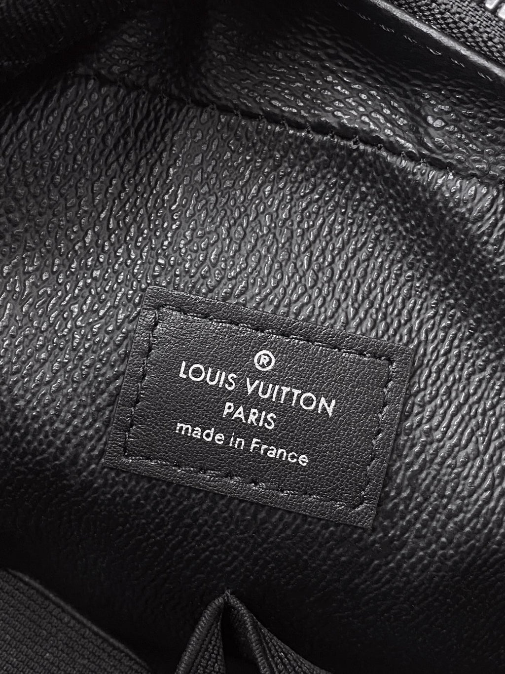Louis Vuitton leather label on black pouch, Paris made in France