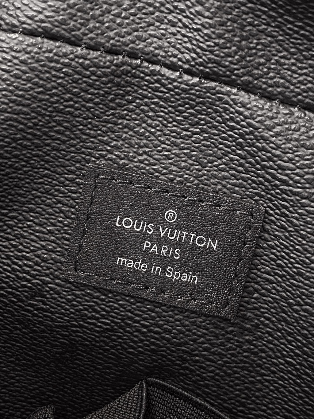 Louis Vuitton small bag interior label reading 'Louis Vuitton Paris, made in Spain'