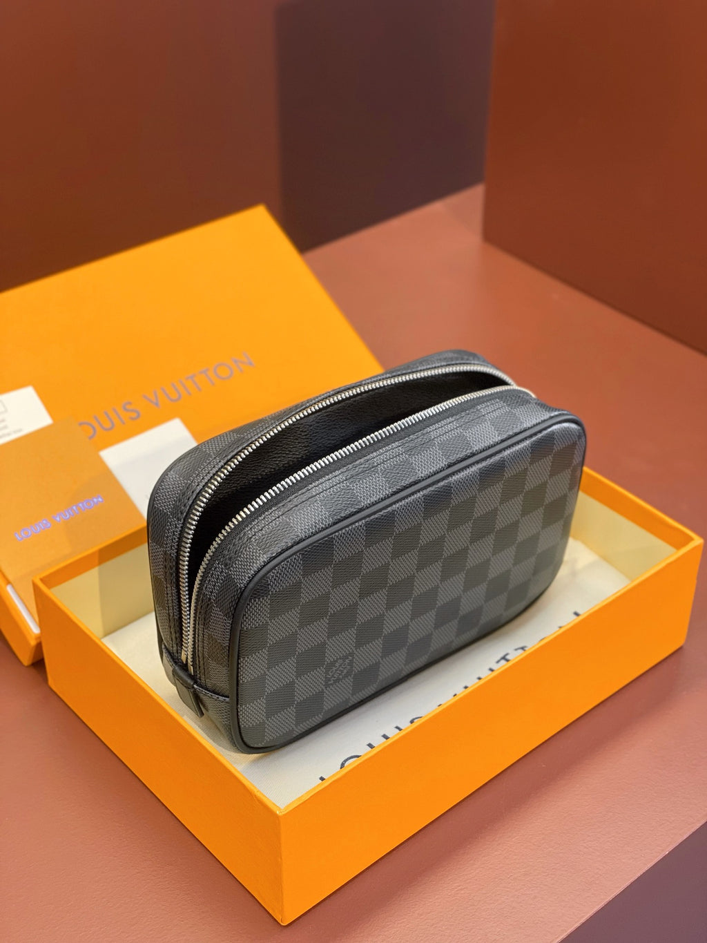 Louis Vuitton checkered zip pouch bag with rounded shape and zipper closure