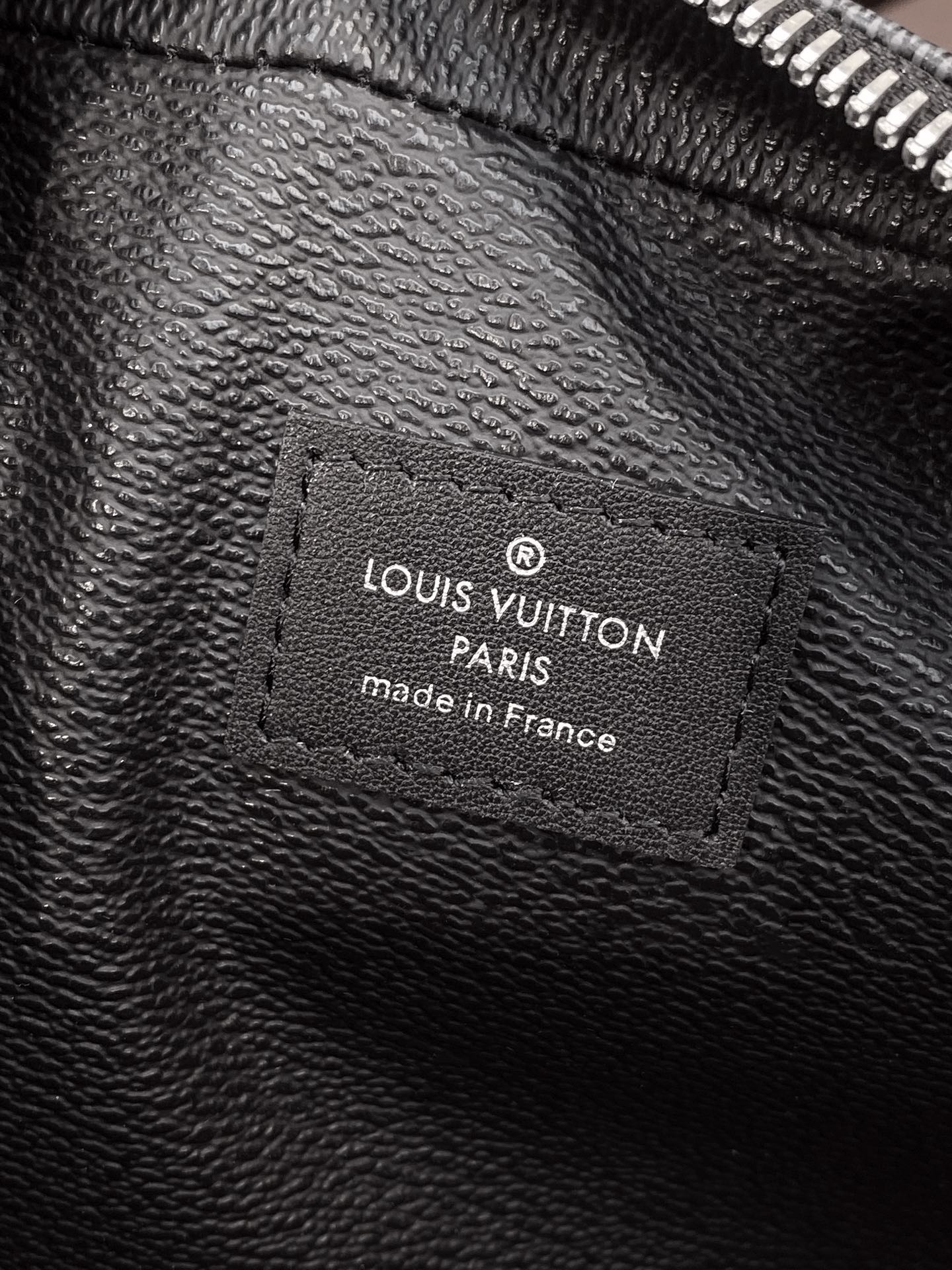 Louis Vuitton Paris logo patch on textured black leather pouch lining