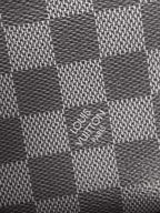 Louis Vuitton checkered Damier pattern fabric on dark pouch surface