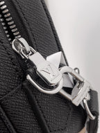 Silver metal zipper pull and snap hardware on black textured leather