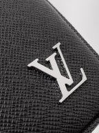 Louis Vuitton monogram metal emblem on black textured leather