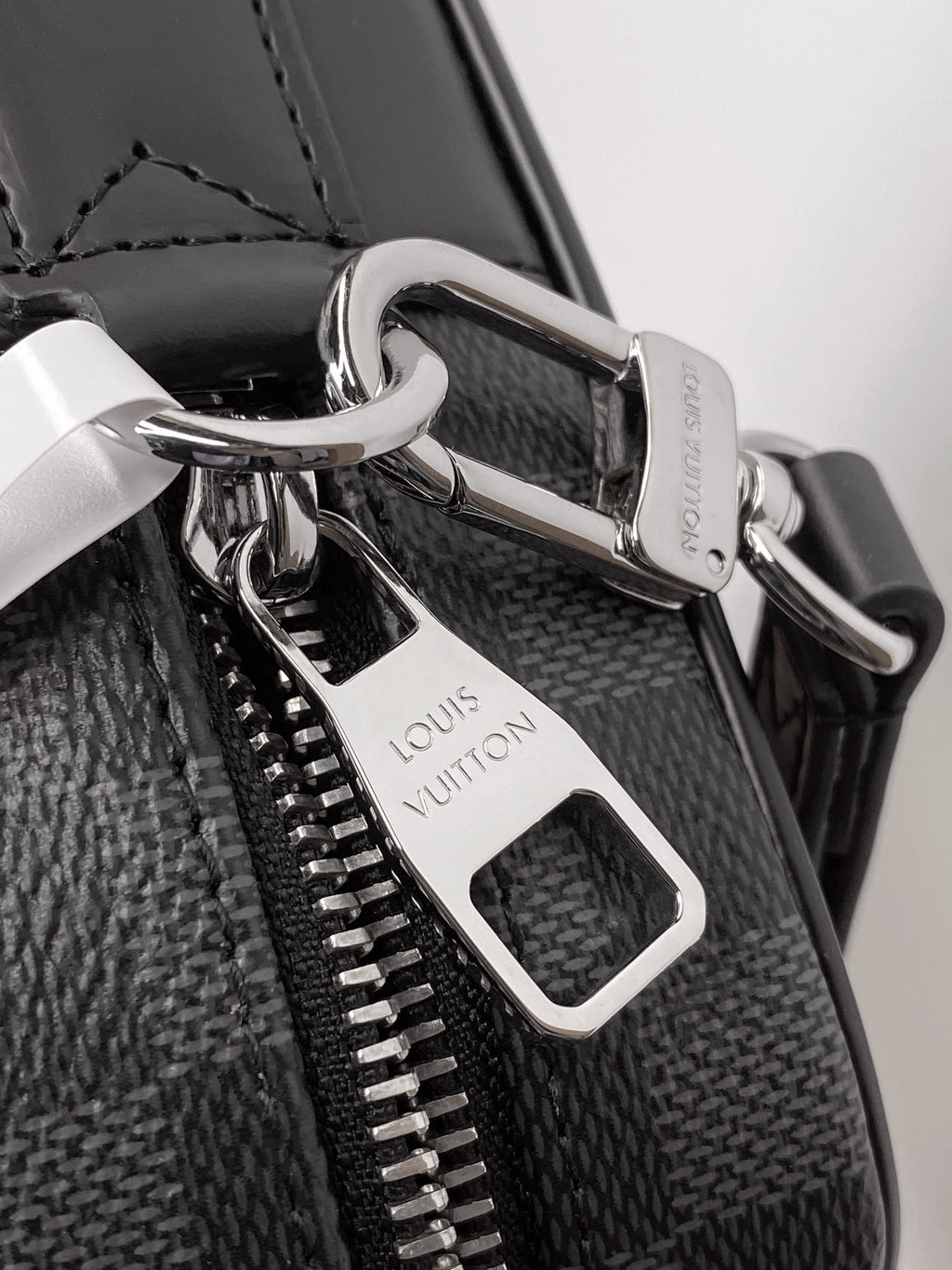 Louis Vuitton bag hardware with silver clasp, zipper pulls, and leather tag