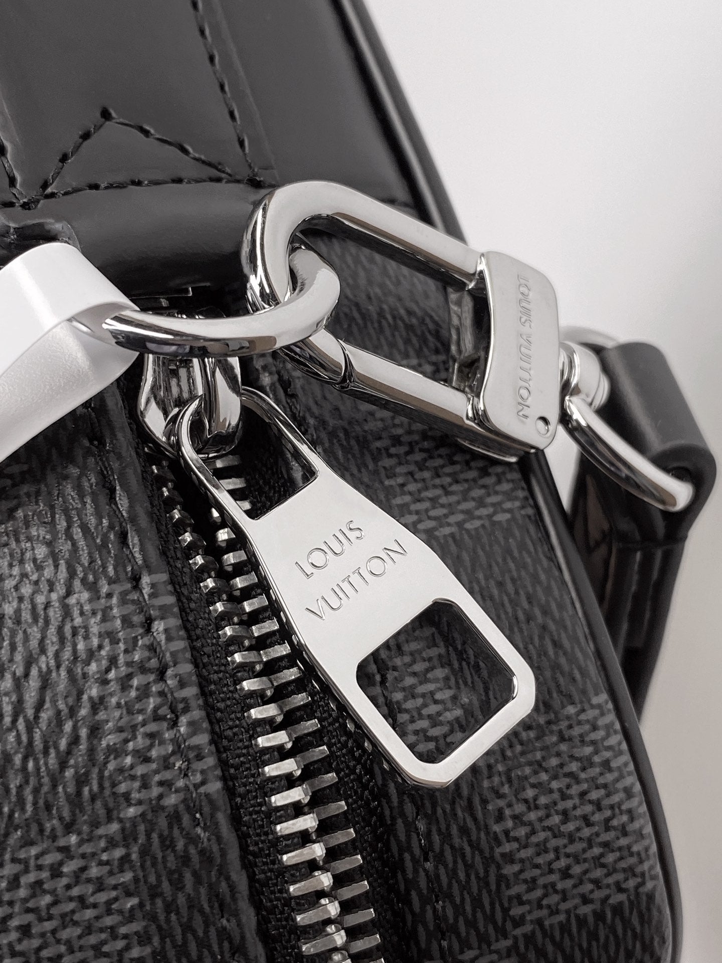 Louis Vuitton bag hardware with silver clasp, zipper pulls, and leather tag
