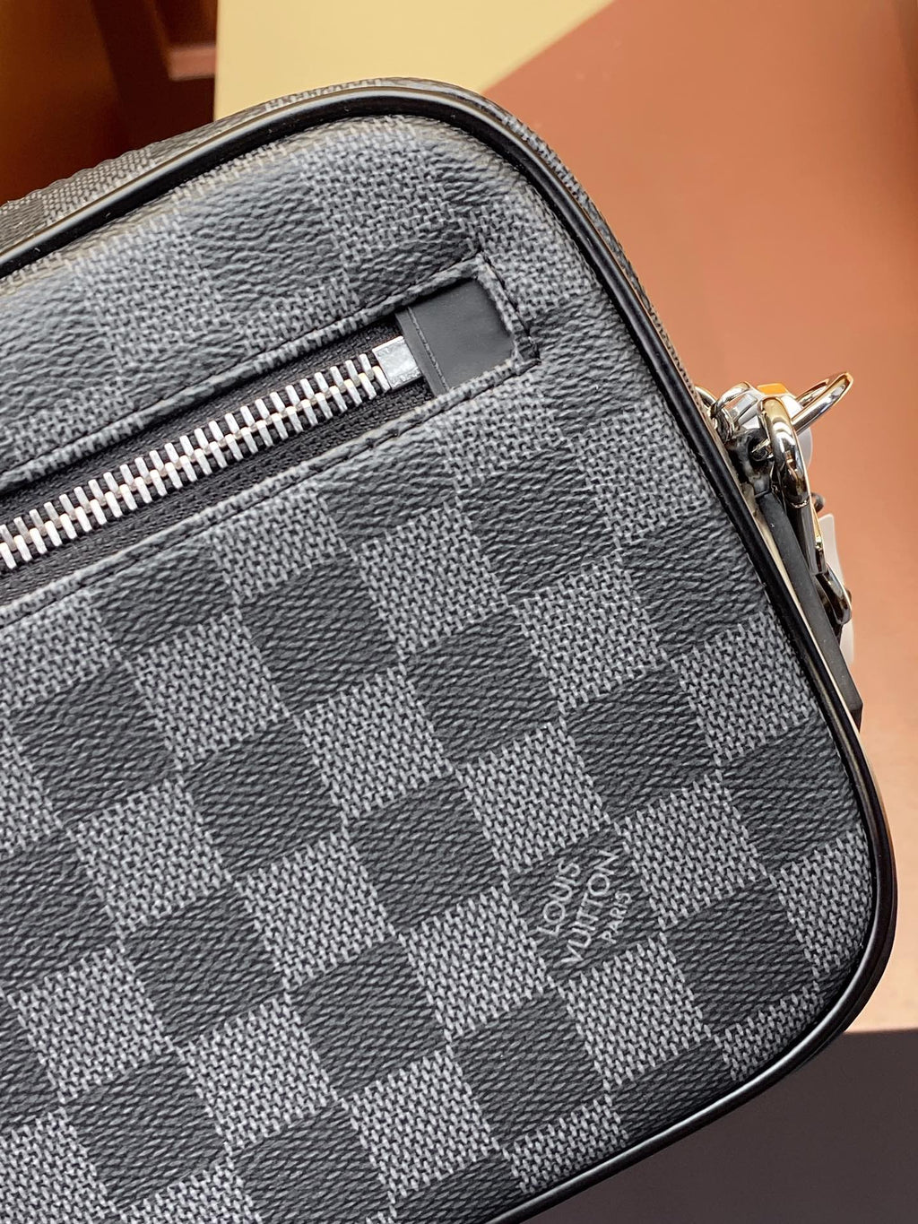 Louis Vuitton check-pattern bag corner with zipper track and leather trim