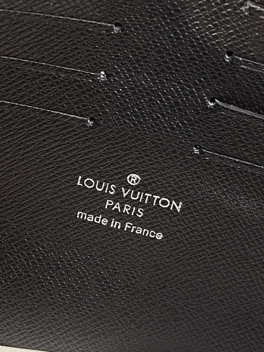 Louis Vuitton Paris logo and Made in France text on dark textured bag leather