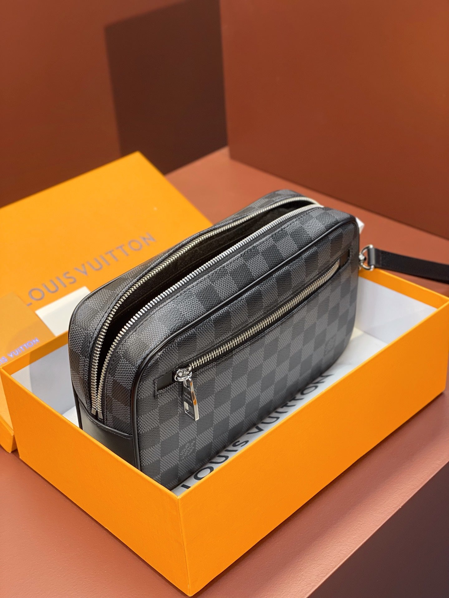 Louis Vuitton small crossbody bag on box display with dark gray Damier checker pattern
