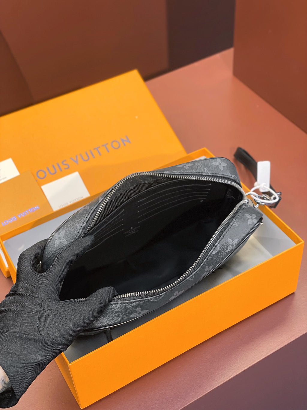 Louis Vuitton small bag interior view with open top zipper and black fabric lining