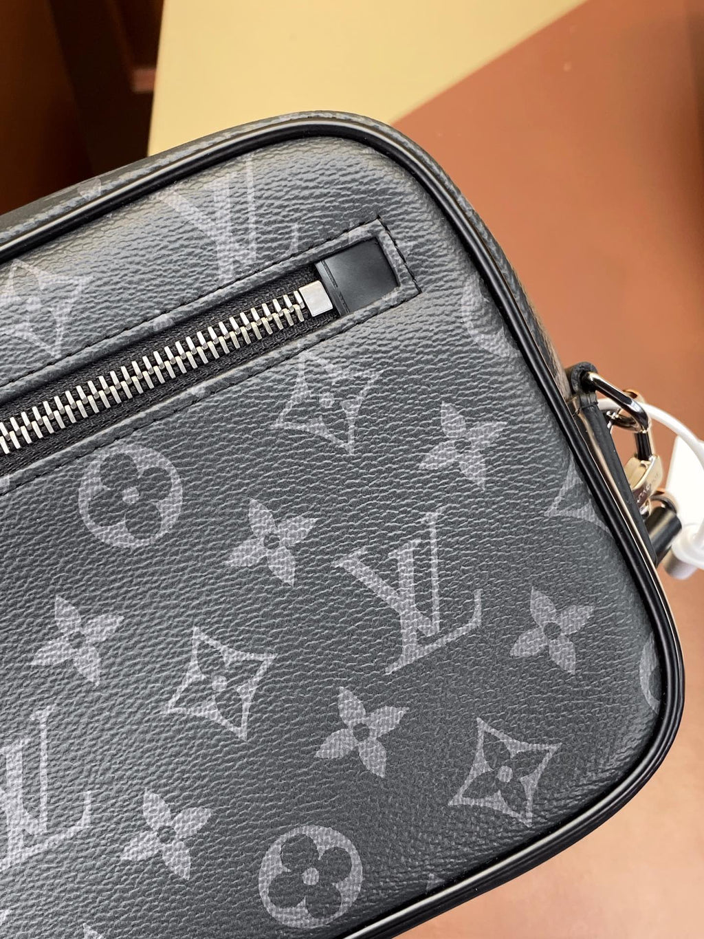 Louis Vuitton small bag close-up with monogram pattern, top zipper, and leather trim