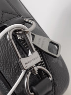 Louis Vuitton small bag hardware close-up with metal ring, swivel clip, and logo tab