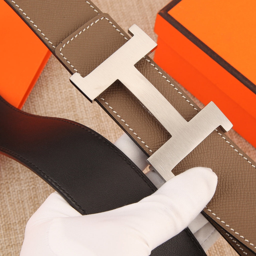 Hermes leather belt buckle close-up, silver H with taupe and dark straps