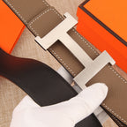 Hermes leather belt buckle close-up, silver H with taupe and dark straps