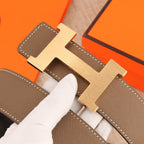 Hermes leather belt buckle detail, silver H on taupe leather with stitching