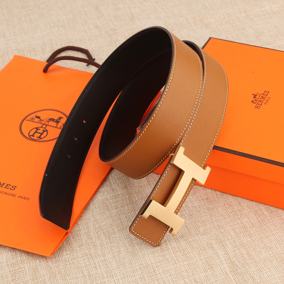 Hermes leather belt with tan exterior, dark underside, and silver buckle