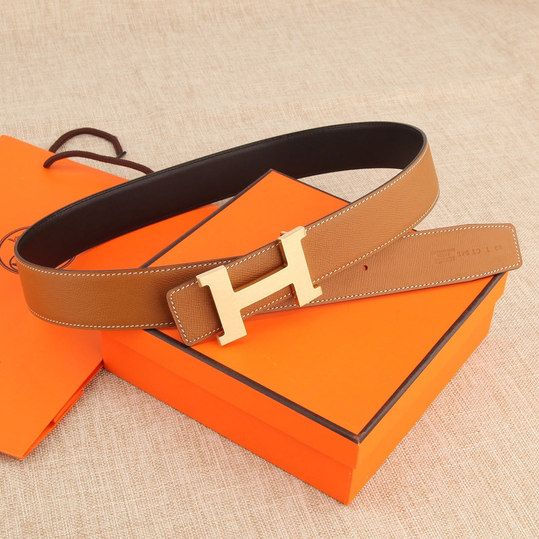 Hermes leather belt with tan strap and silver H-style buckle, laid flat