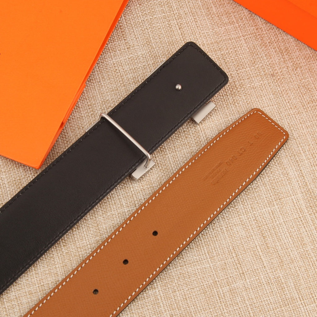 Hermes reversible leather belt showing black and tan sides with silver buckle