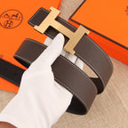 Hermes belt with dark brown leather strap, silver H buckle, and visible white topstitching