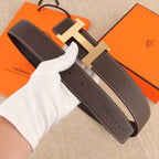 Hermes belt detail: dark brown leather with white stitched edge and silver-tone H buckle