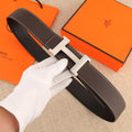 Hermes belt in dark brown leather with silver-tone H buckle and white contrast stitching