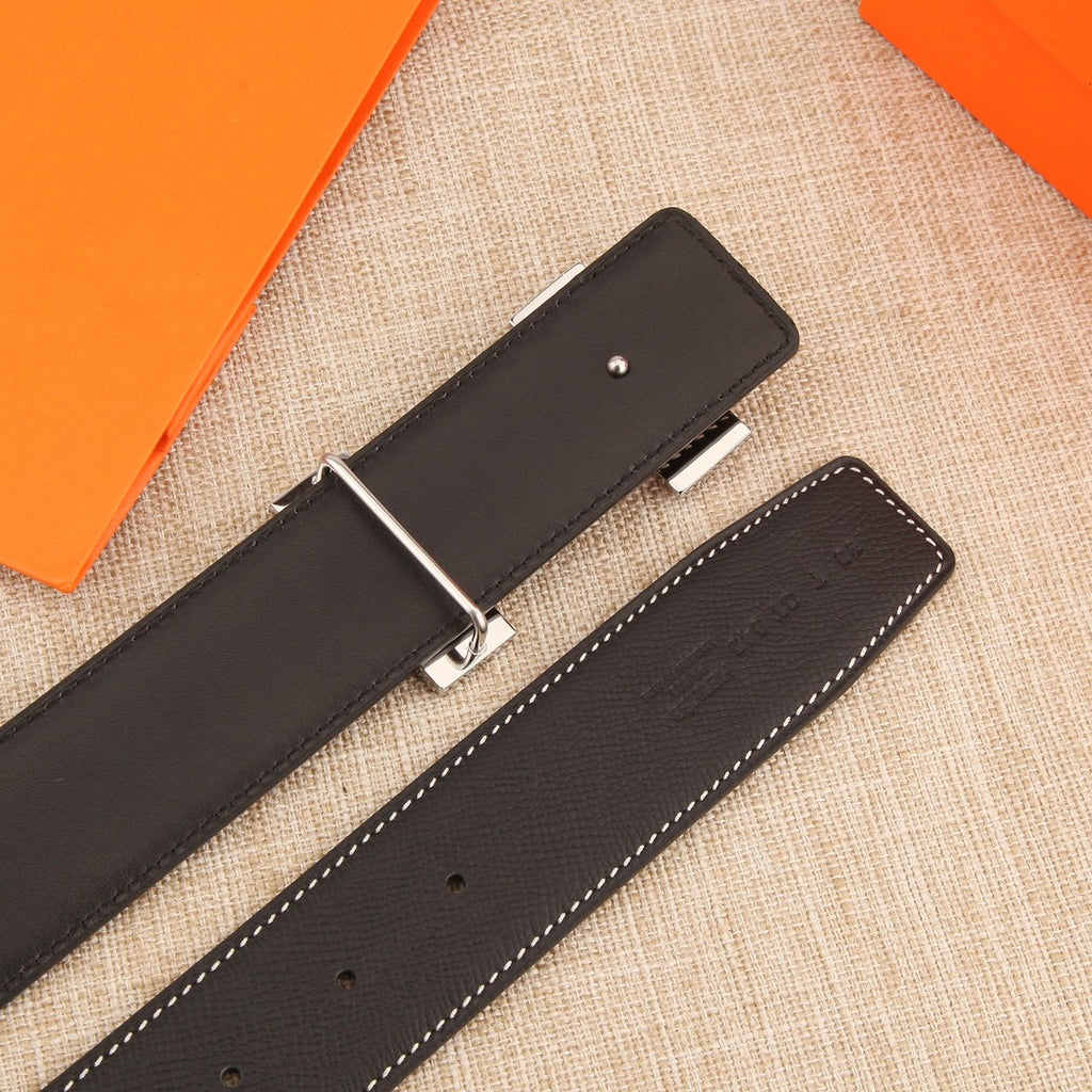 Leather belt showing underside with adjustment holes and keeper tab, dark leather
