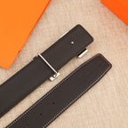 Leather belt showing underside with adjustment holes and keeper tab, dark leather