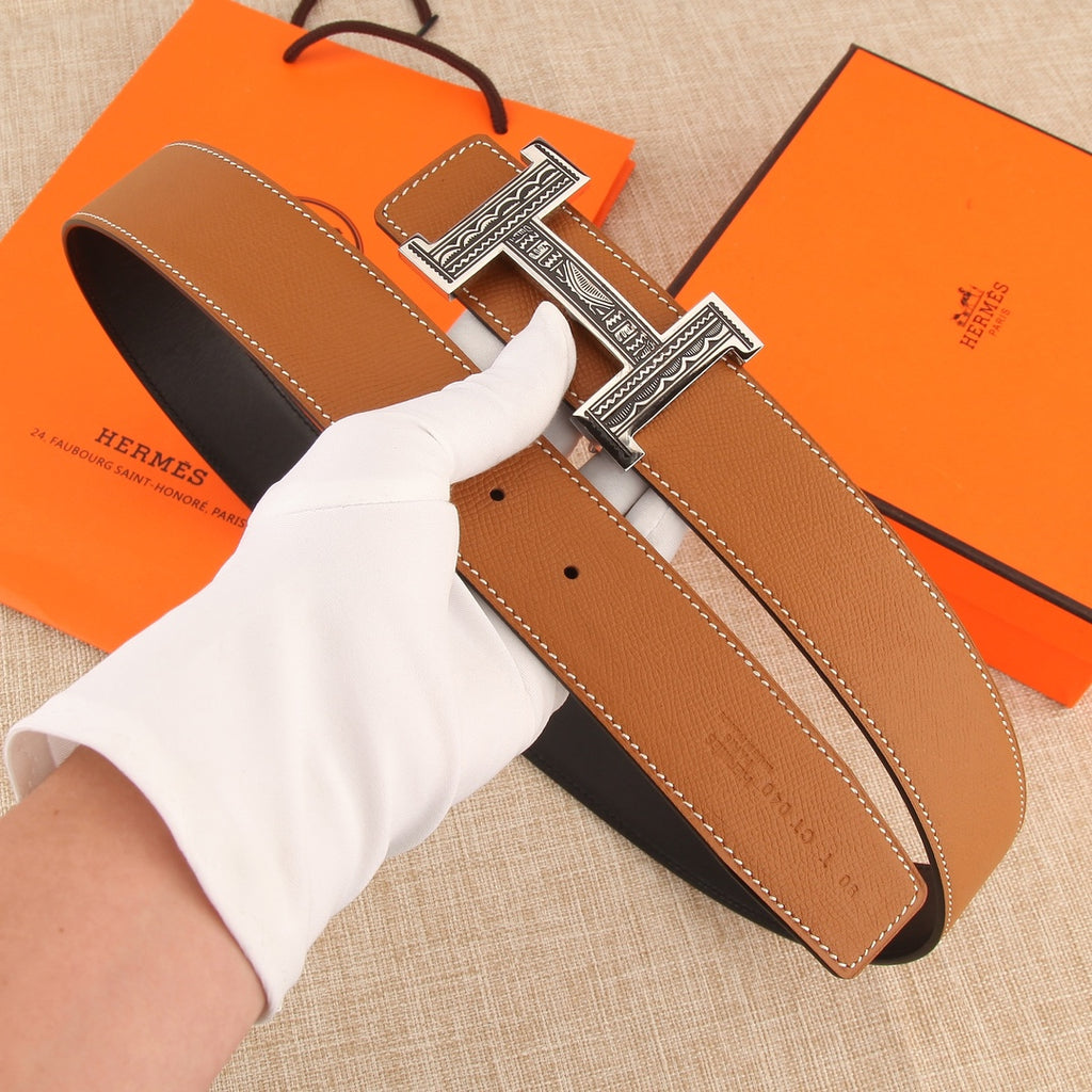 Hermes belt with tan leather strap and silver-tone H buckle, length holes visible.