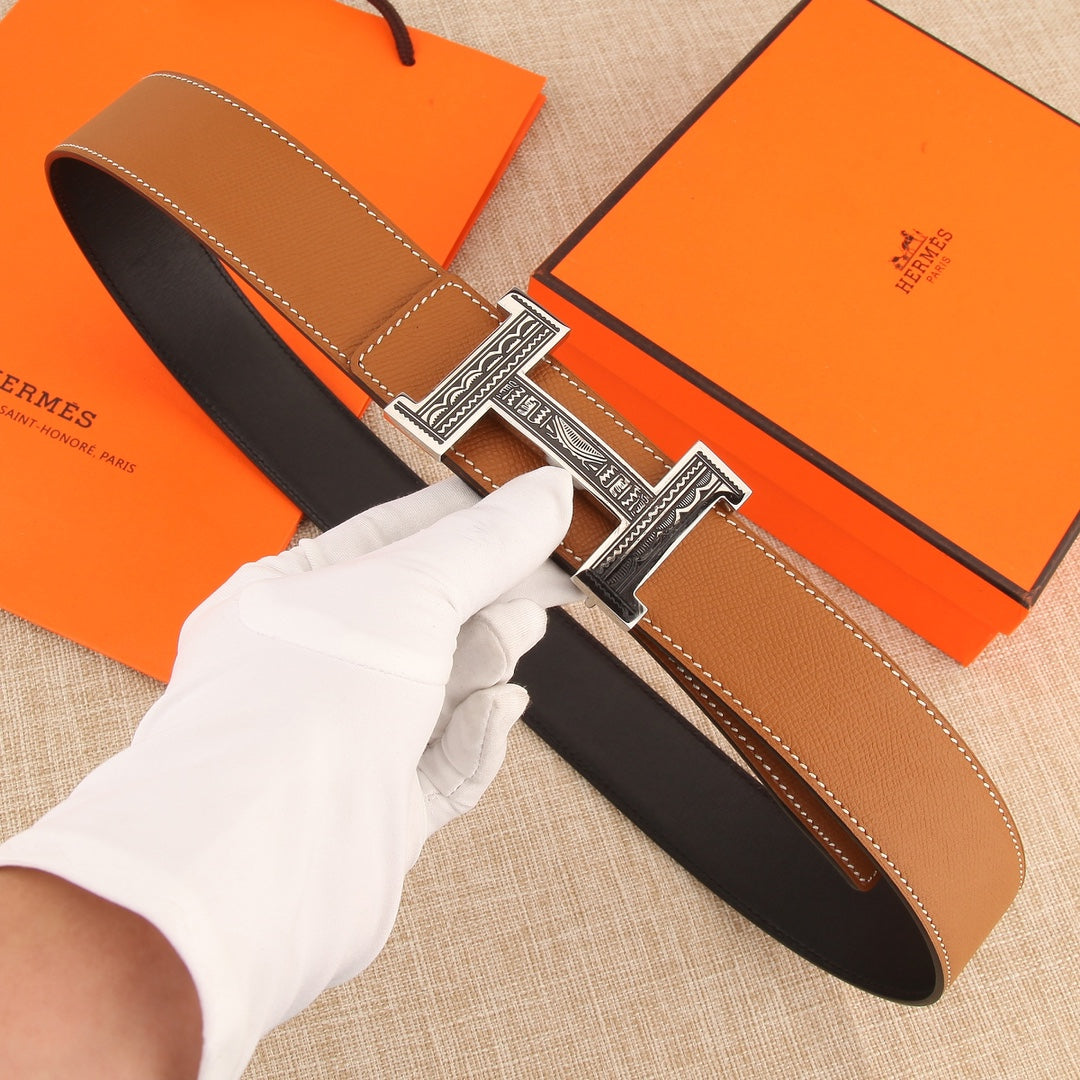 Hermes belt in tan leather with stitched edges and silver-tone H buckle.