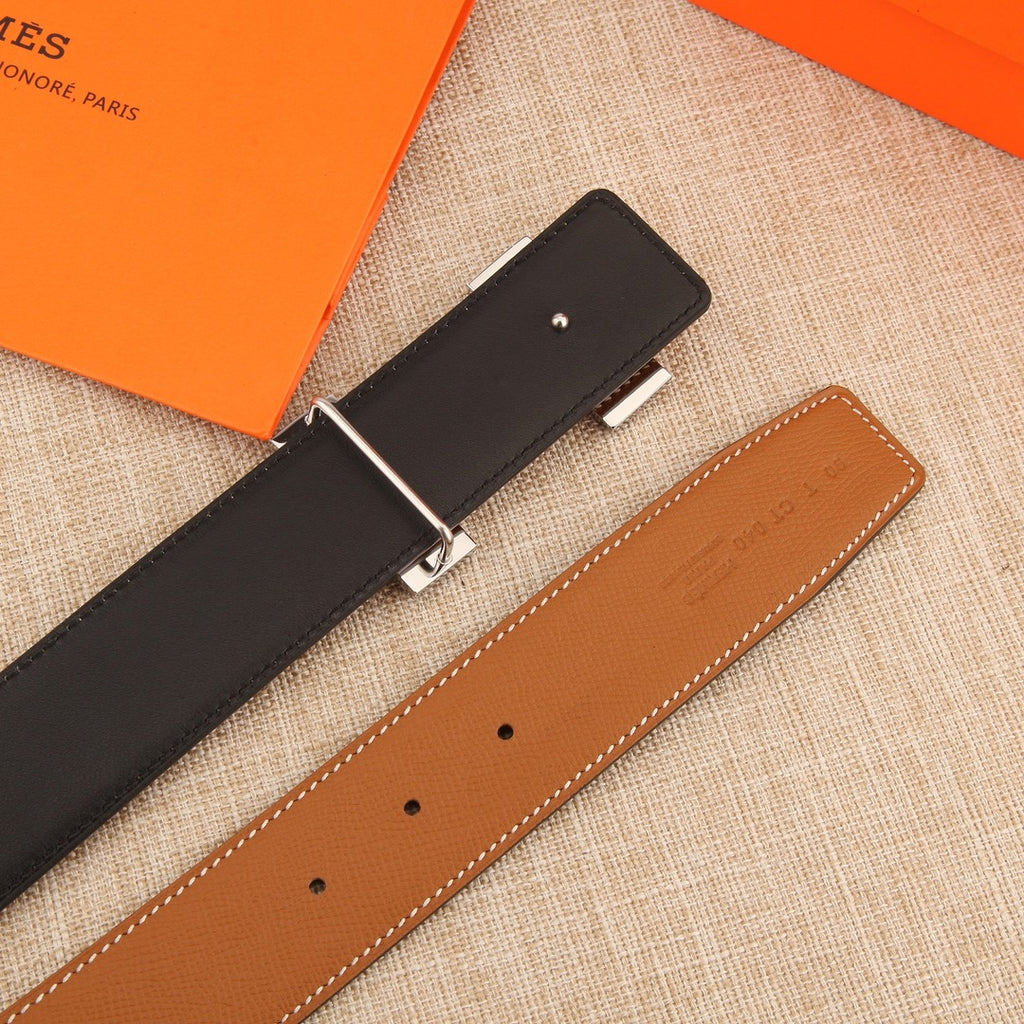 Hermes belt showing two straps: black and tan leather with silver-tone clasp.