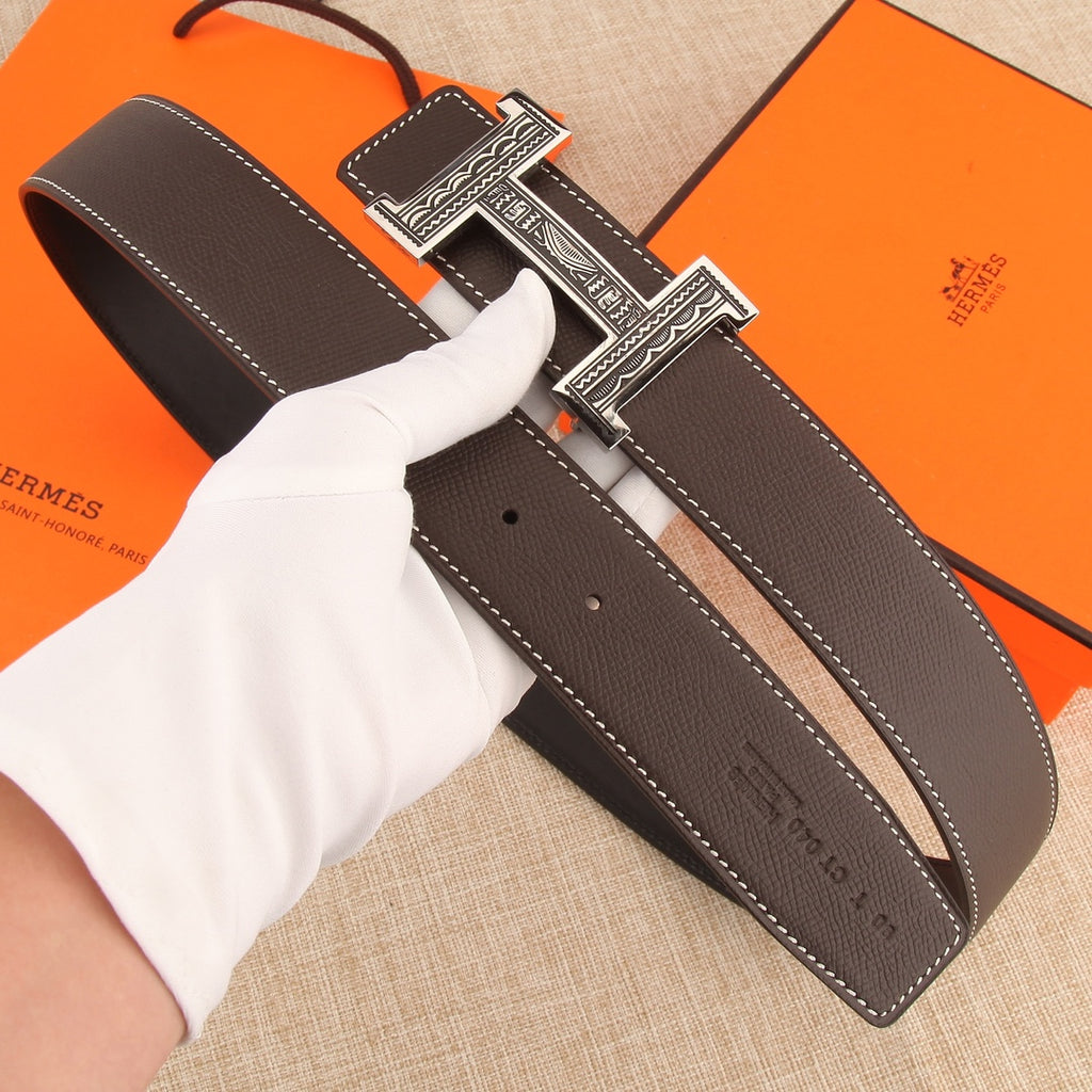 Brown leather belt with silver buckle and stitched edge, showing belt holes