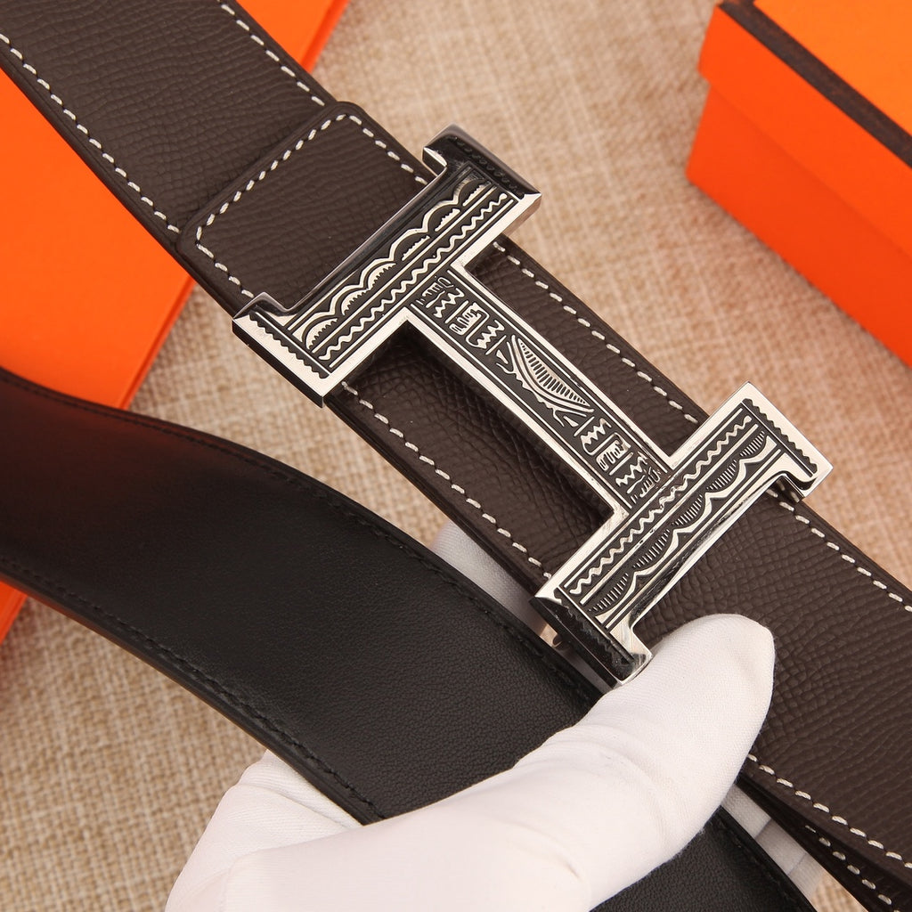 Brown leather belt with silver buckle, strap end, and visible stitching