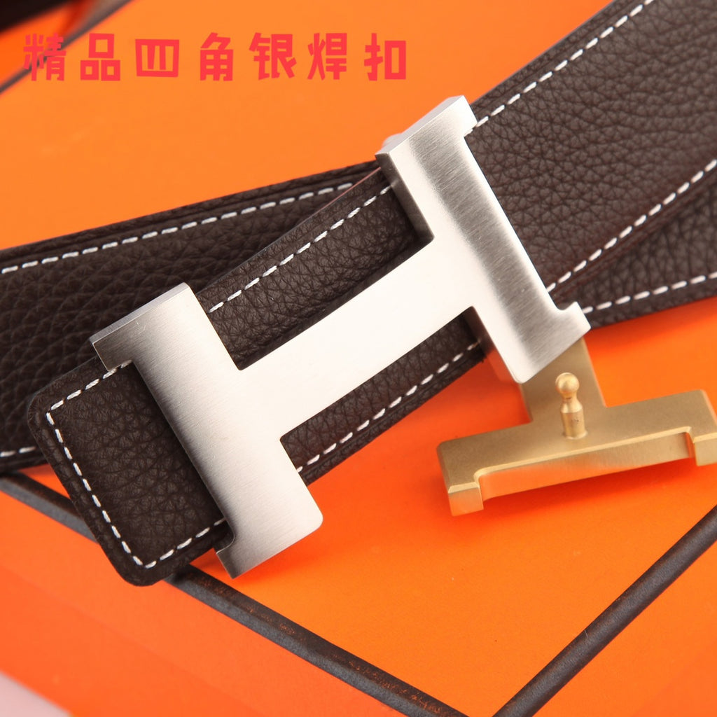 Brown leather belt close-up with gold-tone buckle and white contrast stitching.